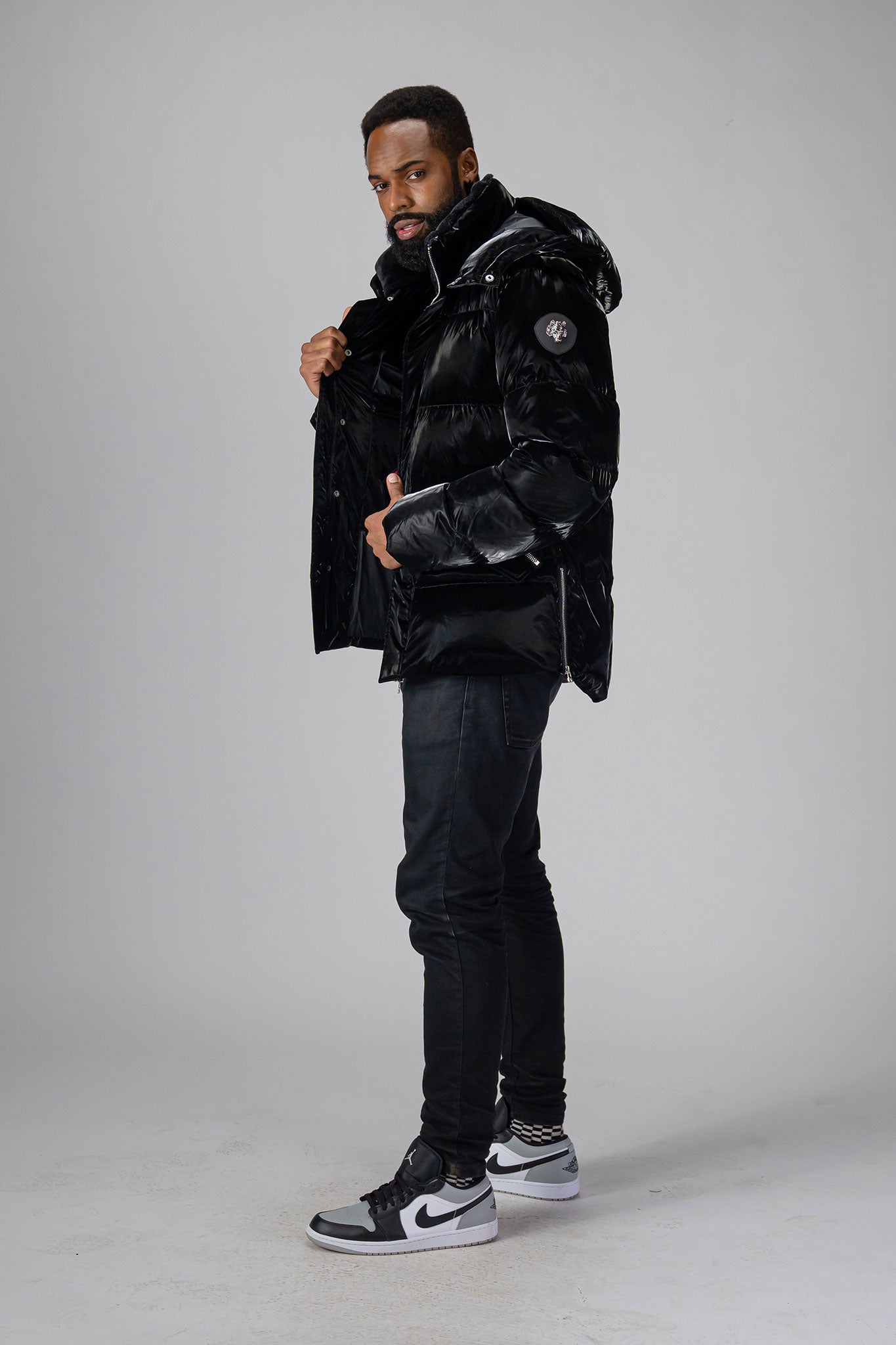 Woodpecker Men's Bumnester Winter coat. High-end Canadian designer winter coat for men in "All Wet Black" colour. Woodpecker cruelty-free winter coat designed in Canada. Men's heavy weight medium length premium designer jacket for winter. Superior quality warm winter coat for men. Moose Knuckles, Canada Goose, Mackage, Montcler, Will Poho, Willbird, Nic Bayley. Shiny parka. Stylish winter jacket. Designer winter coat.