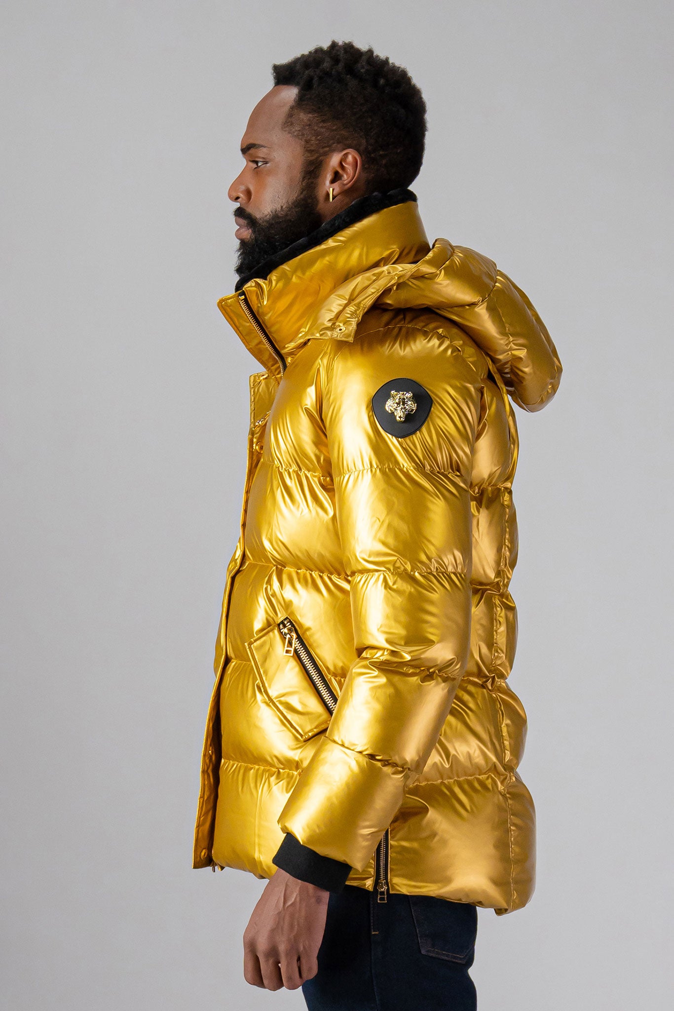 High-end Canadian designer winter coat for men in "Gold" colour. Woodpecker cruelty-free winter coat designed in Canada. Men's heavy weight medium length premium designer jacket for winter. Superior quality warm winter coat for men. Moose Knuckles, Canada Goose, Mackage, Montcler, Will Poho, Willbird, Nic Bayley. Shiny parka. Stylish winter jacket. Designer winter coat.