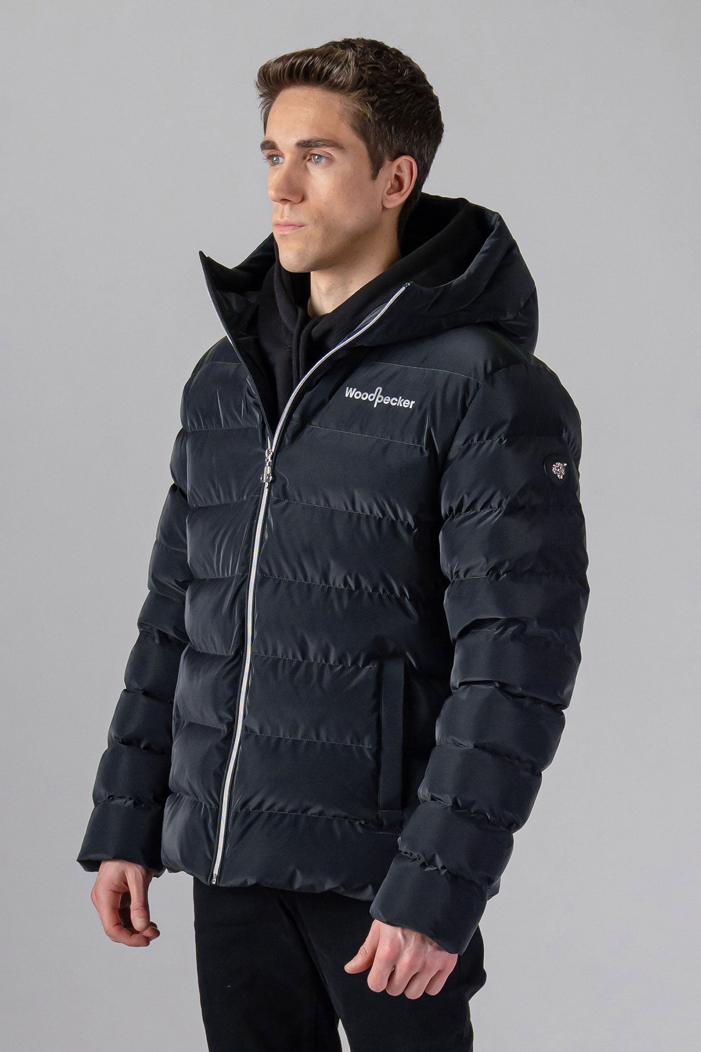 Woodpecker Men's Sparrow Winter coat. High-end Canadian designer winter coat for men in "Black Diamond" colour. Woodpecker cruelty-free winter coat designed in Canada. Men's medium weight medium length premium designer jacket for winter. Superior quality warm winter coat for men. Moose Knuckles, Canada Goose, Mackage, Montcler, Will Poho, Willbird, Nic Bayley. Shiny parka. Stylish winter jacket. Designer winter coat.