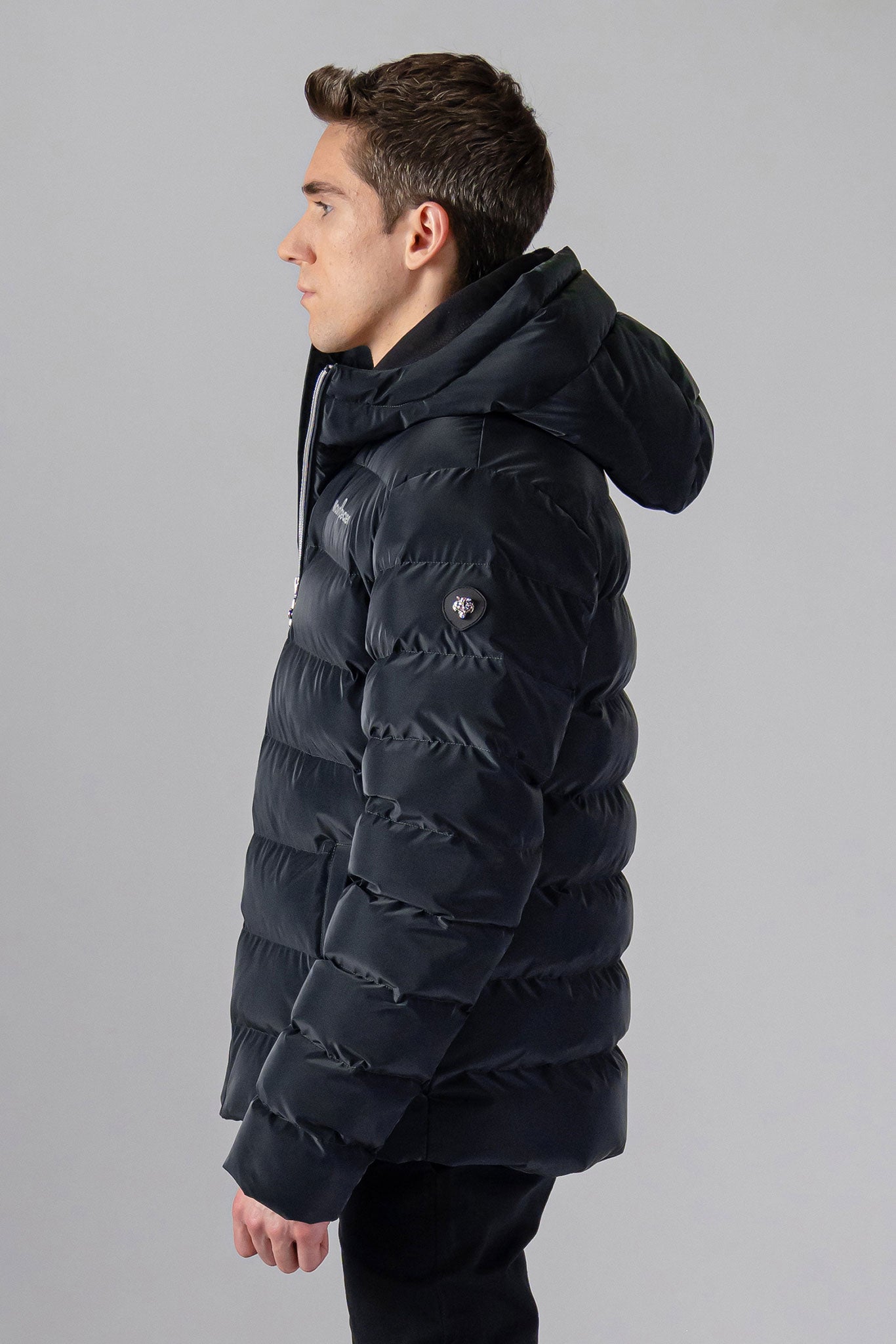 Woodpecker Men's Sparrow Winter coat. High-end Canadian designer winter coat for men in "Black Diamond" colour. Woodpecker cruelty-free winter coat designed in Canada. Men's medium weight medium length premium designer jacket for winter. Superior quality warm winter coat for men. Moose Knuckles, Canada Goose, Mackage, Montcler, Will Poho, Willbird, Nic Bayley. Shiny parka. Stylish winter jacket. Designer winter coat.