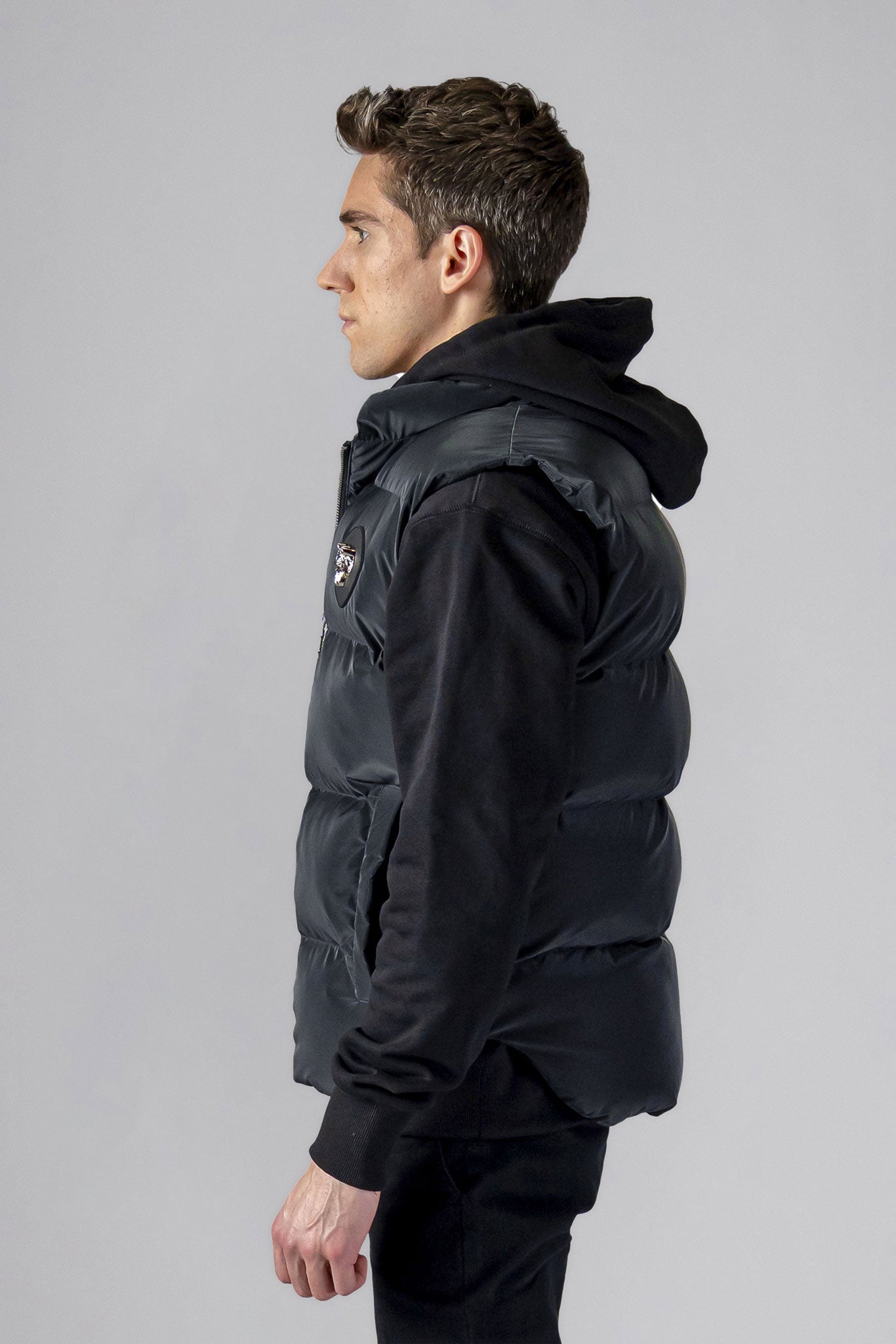 Woodpecker Unisex Winter Vest. High-end Canadian designer winter vest in "Black Diamond" colour. Woodpecker cruelty-free vest designed in Canada. Heavy weight short length premium designer vest for winter. Superior quality warm winter vest. Moose Knuckles, Canada Goose, Mackage, Montcler, Will Poho, Willbird, Nic Bayley. Extra warm. Shiny vest. Stylish winter vest. Designer winter vest.