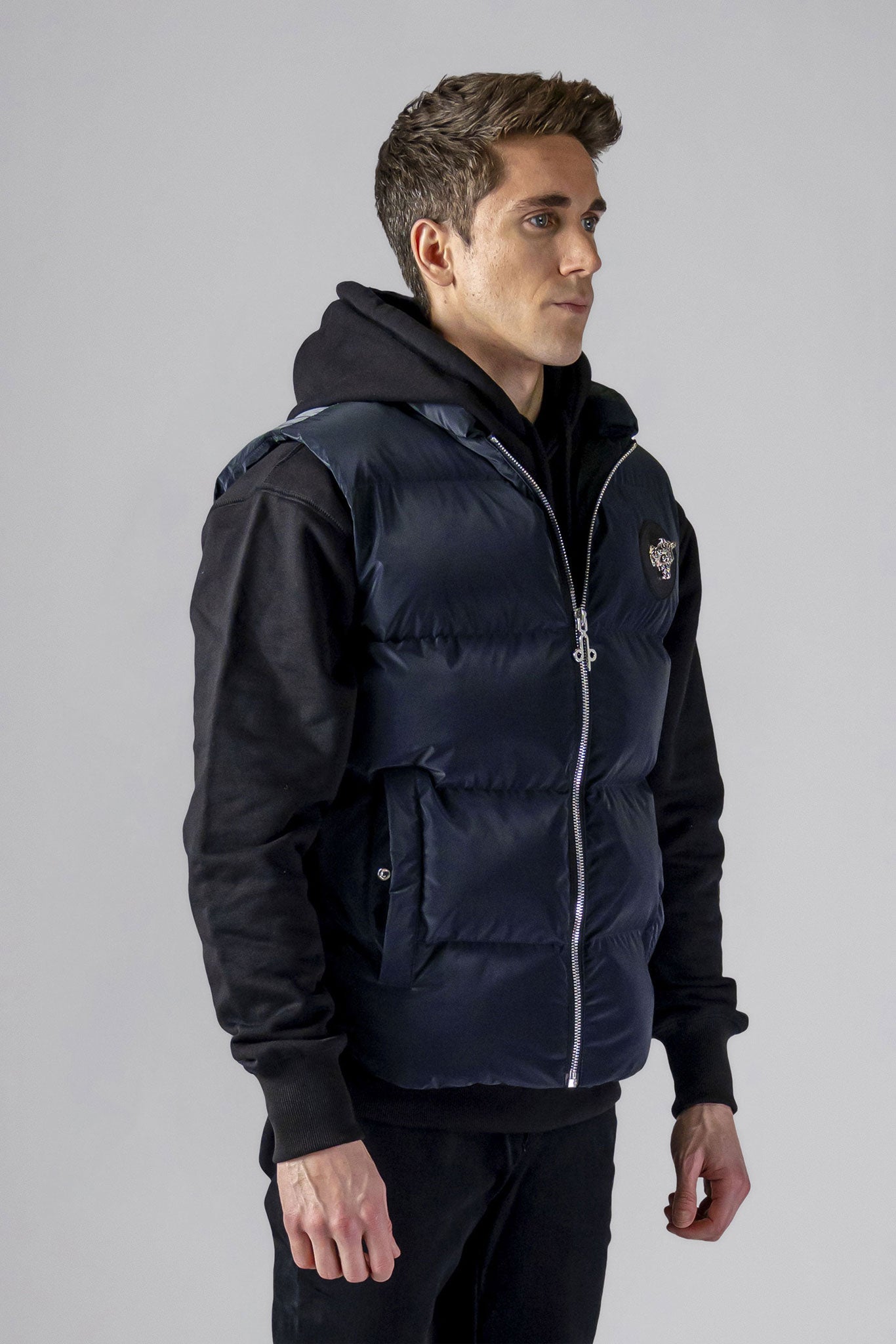 Woodpecker Unisex Winter Vest. High-end Canadian designer winter vest in "Blue Diamond" colour. Woodpecker cruelty-free vest designed in Canada. Heavy weight short length premium designer vest for winter. Superior quality warm winter vest. Moose Knuckles, Canada Goose, Mackage, Montcler, Will Poho, Willbird, Nic Bayley. Extra warm. Shiny vest. Stylish winter vest. Designer winter vest.