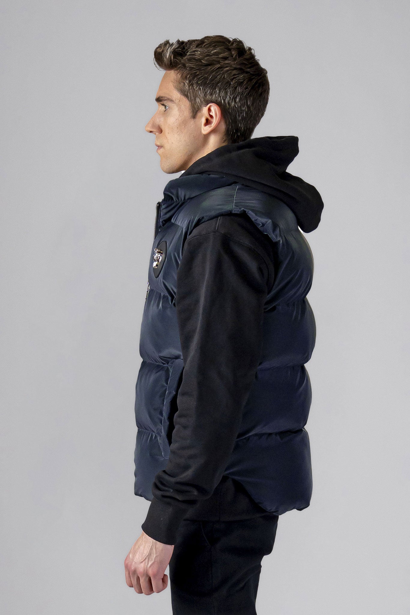 Woodpecker Unisex Winter Vest. High-end Canadian designer winter vest in "Blue Diamond" colour. Woodpecker cruelty-free vest designed in Canada. Heavy weight short length premium designer vest for winter. Superior quality warm winter vest. Moose Knuckles, Canada Goose, Mackage, Montcler, Will Poho, Willbird, Nic Bayley. Extra warm. Shiny vest. Stylish winter vest. Designer winter vest.