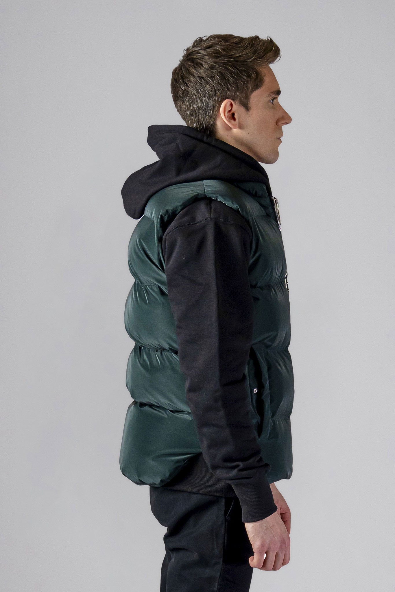 Woodpecker Unisex Winter Vest. High-end Canadian designer winter vest in "Green Diamond" colour. Woodpecker cruelty-free vest designed in Canada. Heavy weight short length premium designer vest for winter. Superior quality warm winter vest. Moose Knuckles, Canada Goose, Mackage, Montcler, Will Poho, Willbird, Nic Bayley. Extra warm. Shiny vest. Stylish winter vest. Designer winter vest.