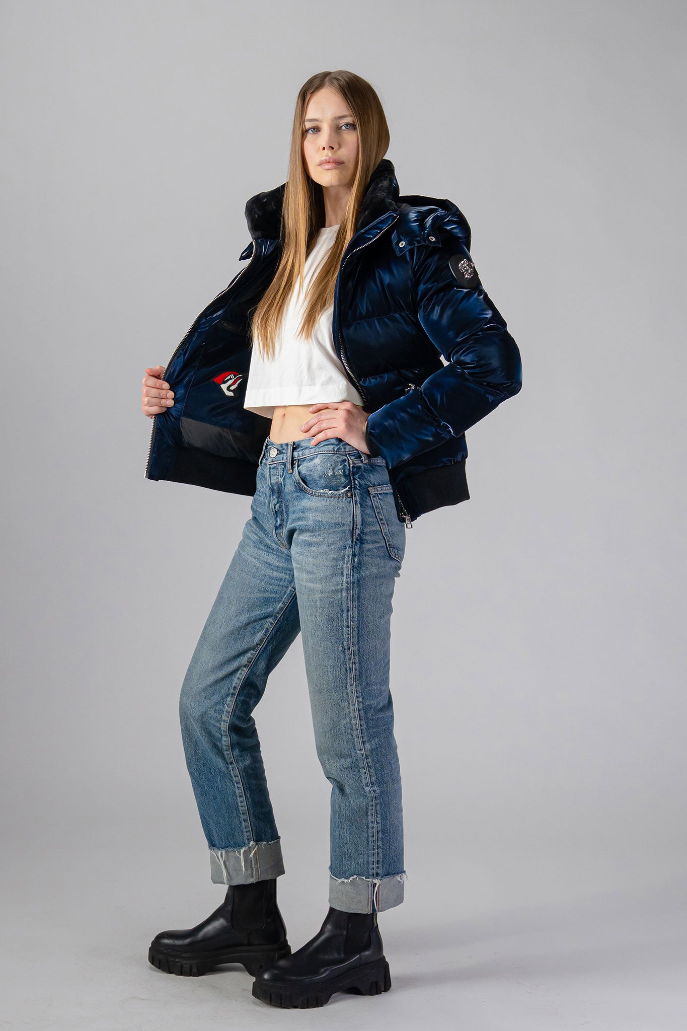 Woodpecker Women's Woody Bomber Winter coat. High-end Canadian designer winter coat for women in shiny “All Wet Navy". Woodpecker cruelty-free winter coat designed in Canada. Women's heavy weight short length premium designer jacket for winter. Superior quality warm winter coat for women. Moose Knuckles, Canada Goose, Mackage, Montcler, Will Poho, Willbird, Nic Bayley. Shiny parka. Stylish winter jacket. Designer winter coat.