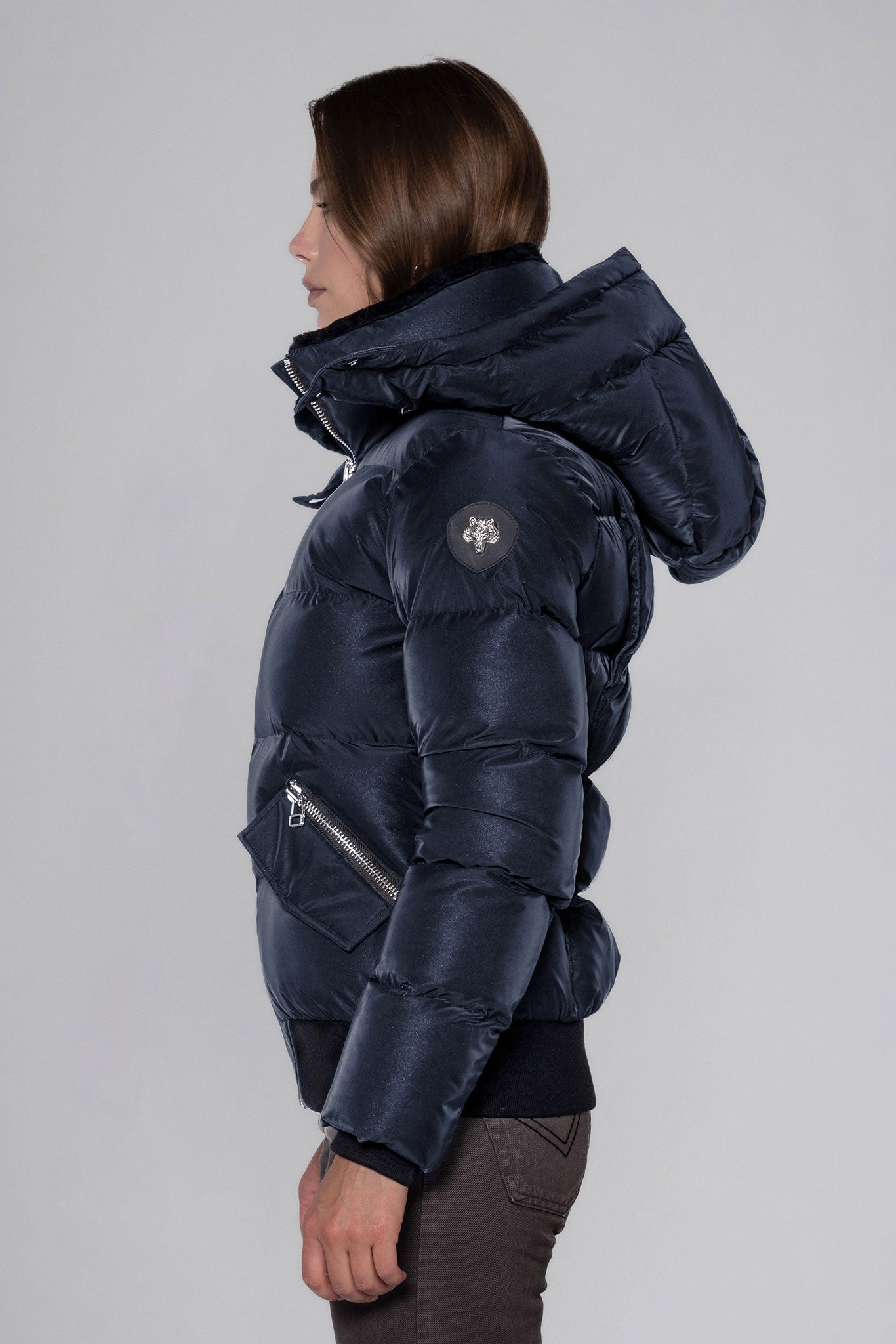 Woodpecker Women's Woody Bomber Winter coat. High-end Canadian designer winter coat for women in "Blue Diamond" colour. Woodpecker cruelty-free winter coat designed in Canada. Women's heavy weight short length premium designer jacket for winter. Superior quality warm winter coat for women. Moose Knuckles, Canada Goose, Mackage, Montcler, Will Poho, Willbird, Nic Bayley. Shiny parka. Stylish winter jacket. Designer winter coat.