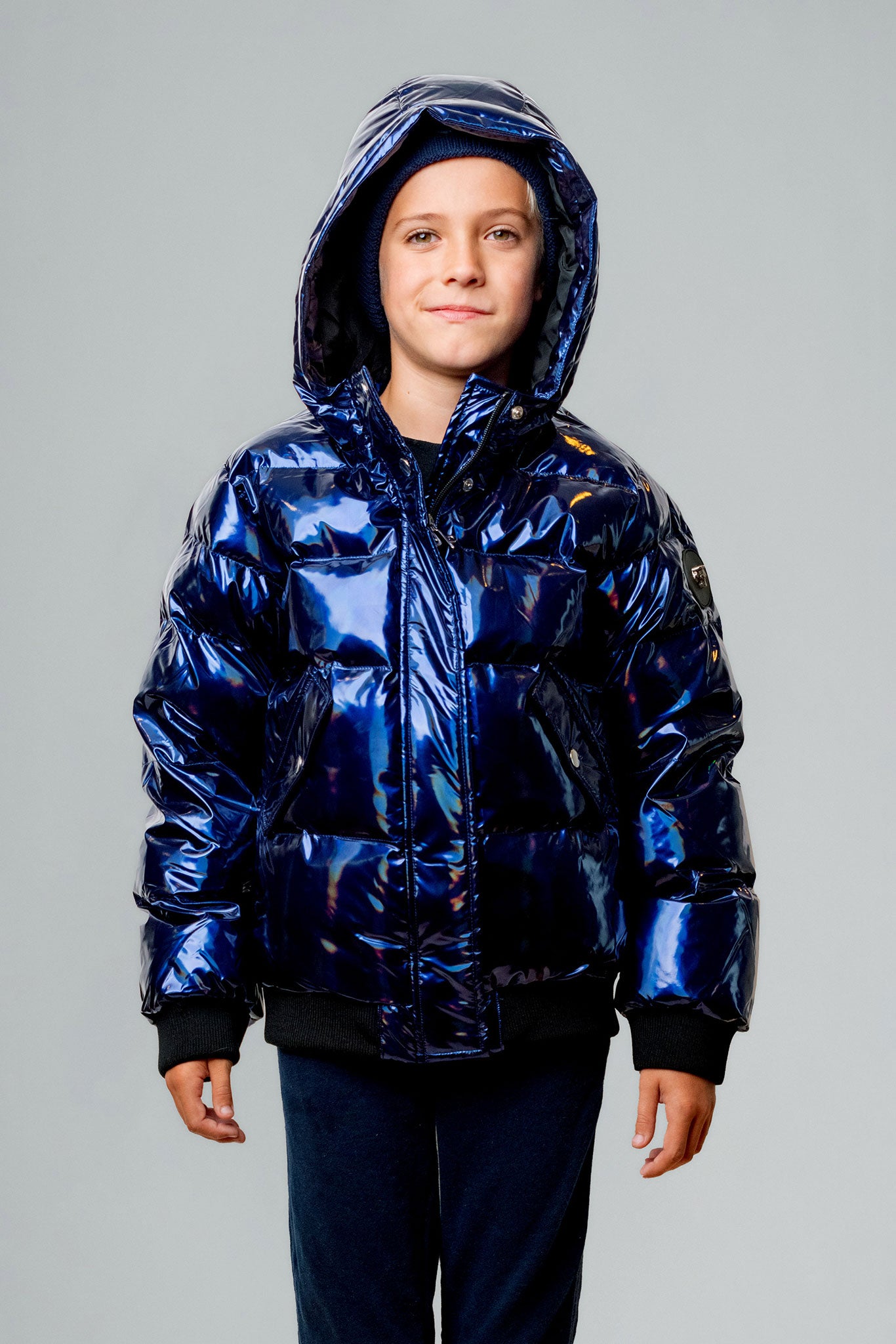 Woodpecker Kids' Chickadee Winter coat. High-end Canadian designer winter coat for Kids in "Oily Blue" colour. Woodpecker cruelty-free winter coat designed in Canada. Kids' heavy weight short length premium designer jacket for winter. Superior quality warm winter coat for kids. Moose Knuckles, Canada Goose, Mackage, Montcler, Will Poho, Willbird, Nic Bayley. Extra warm. Shiny parka. Stylish winter jacket. Designer winter coat.
